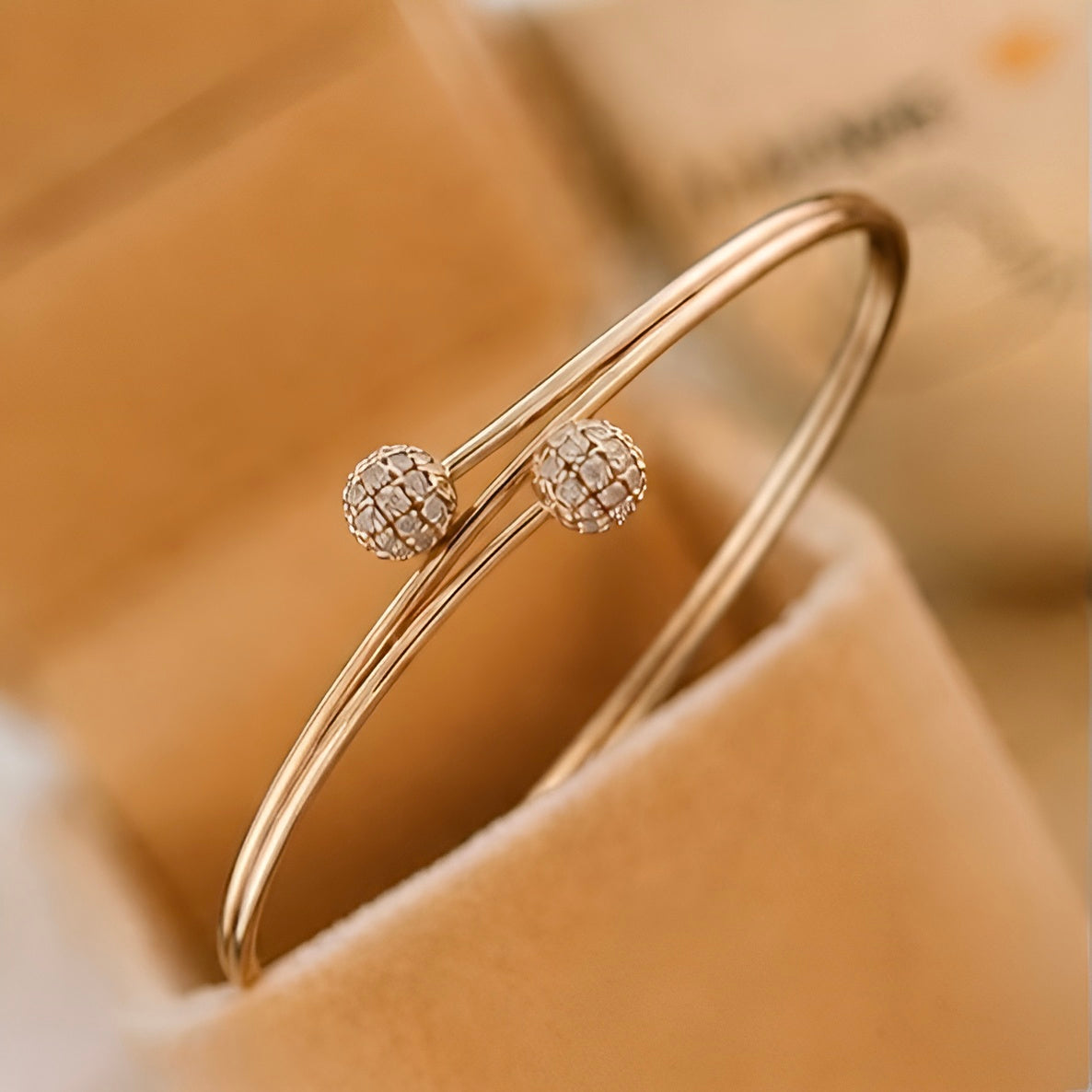 Prifine twin sphere open bangle in 18K gold plating with sleek, modern design and smooth, rounded spheres on a shiny gold finish.