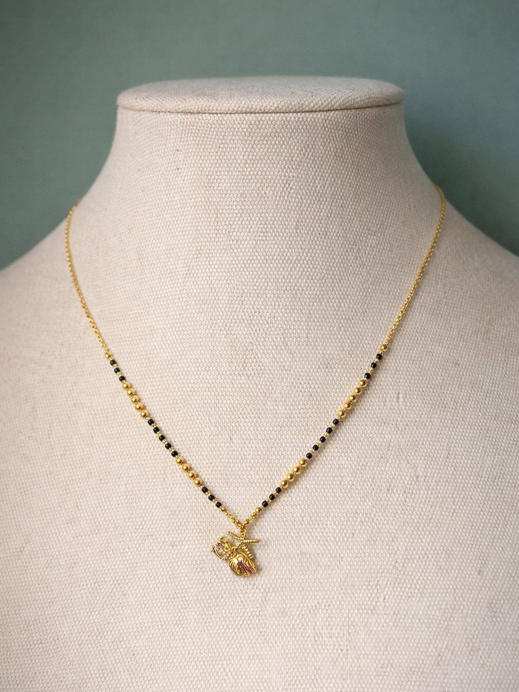 Elegant Golden Aura Mangalsutra by Prifine featuring intricate gold chain design and traditional black bead accents.