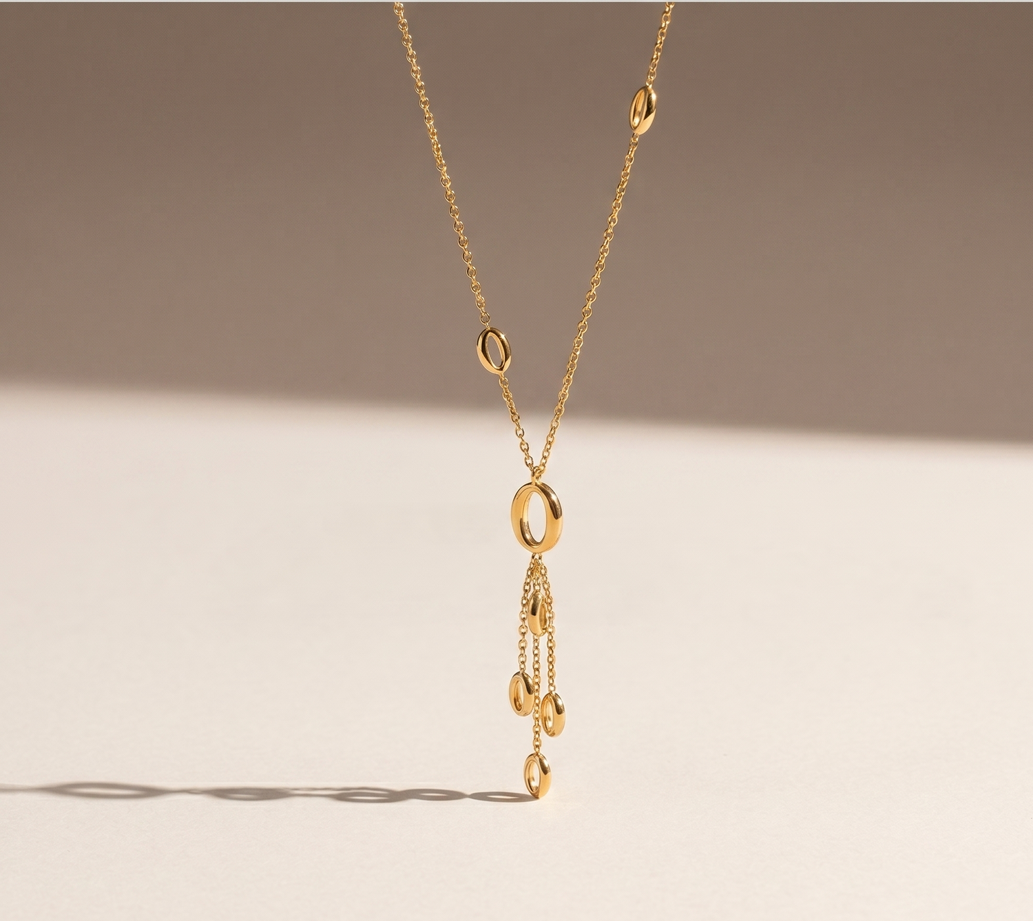 Prifine gold drop pendant necklace featuring dangling circular charms on a delicate chain.