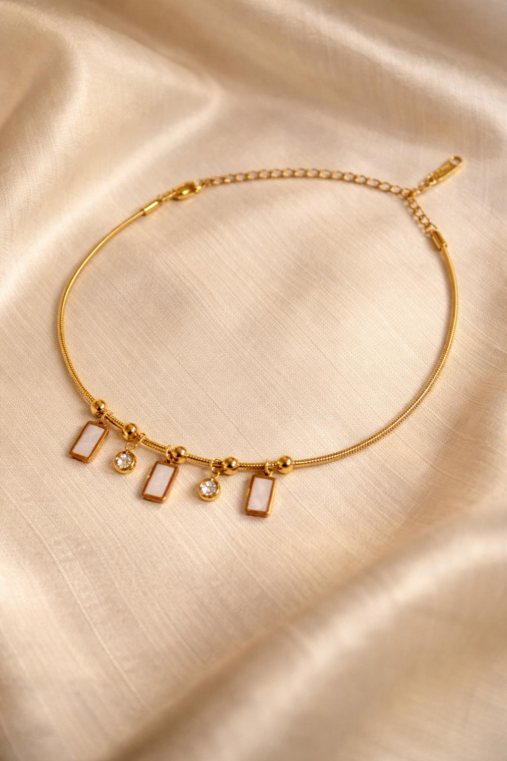 Gold plated charm bracelet by Prifine featuring assorted decorative charms on a delicate chain.