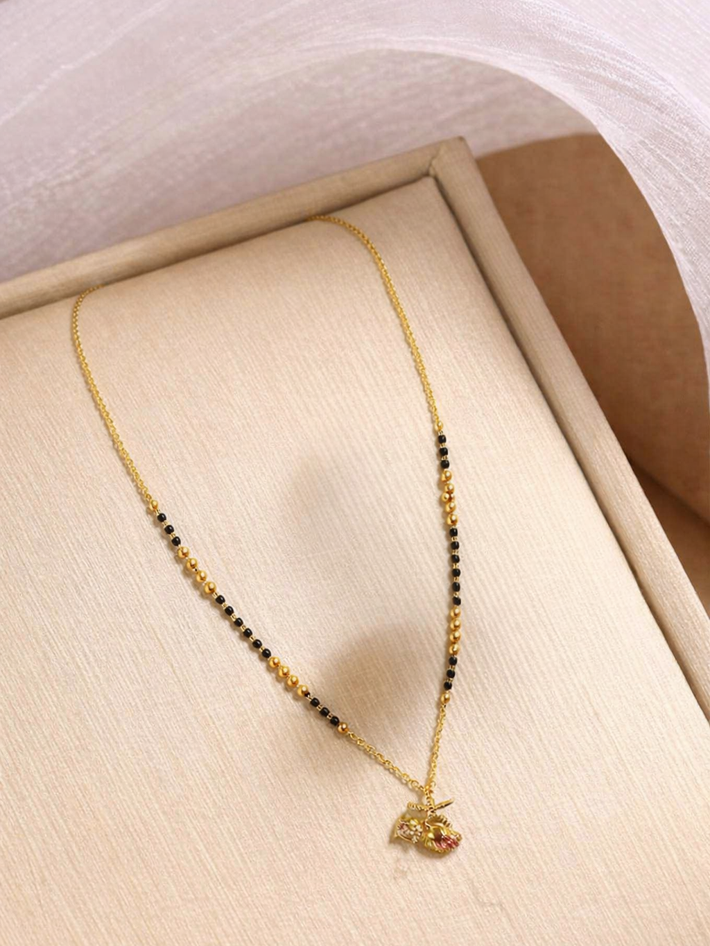 Golden Aura Mangalsutra by Prifine featuring a traditional black beaded chain and elegant gold pendant.