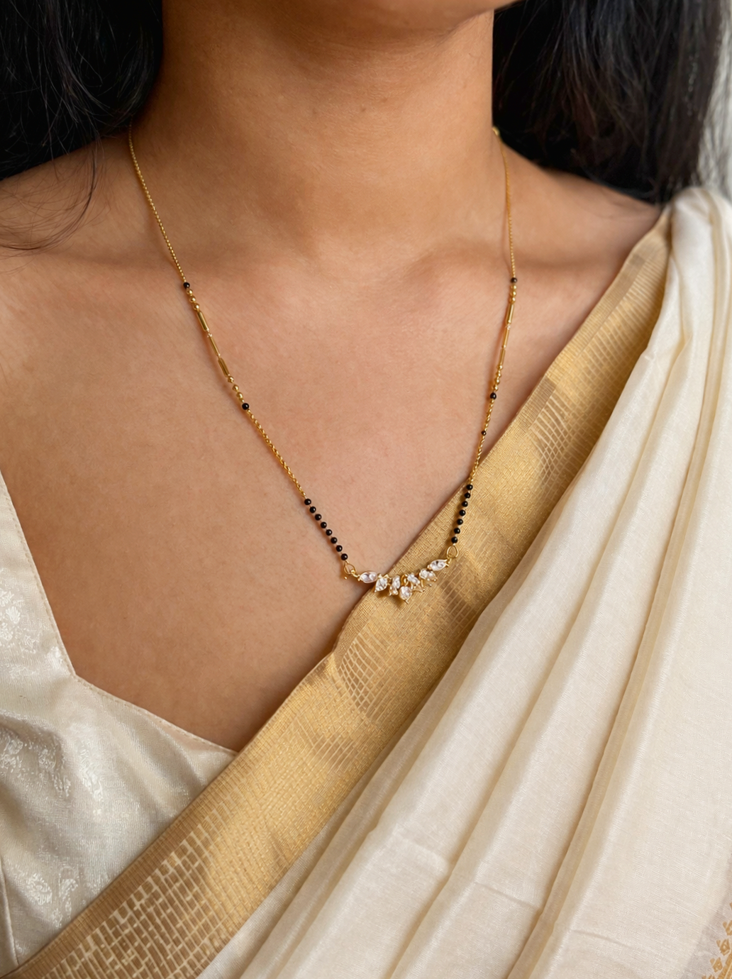 Prifine Saruchi Mangalsutra featuring intricate gold design with black beads and traditional pendant, on a white background.